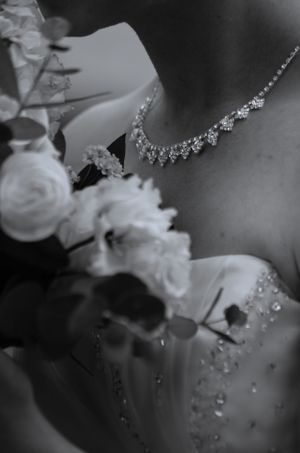 Delicate crystal jewelry and floral details captured in black and white macro photography.