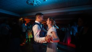 Wedding couple shares their first dance under dramatic blue lighting at their reception.