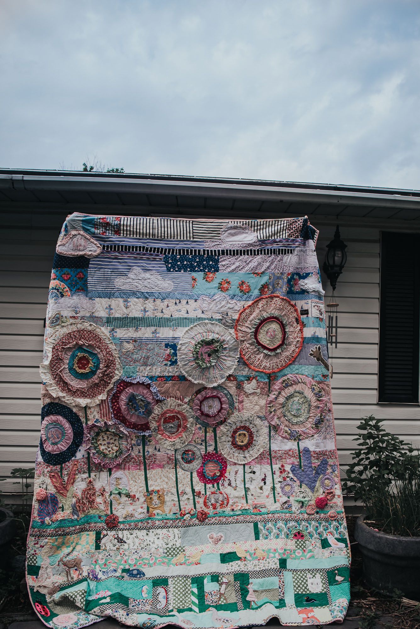 Queen size custom memory quilt with a large garden scene made from appliques.