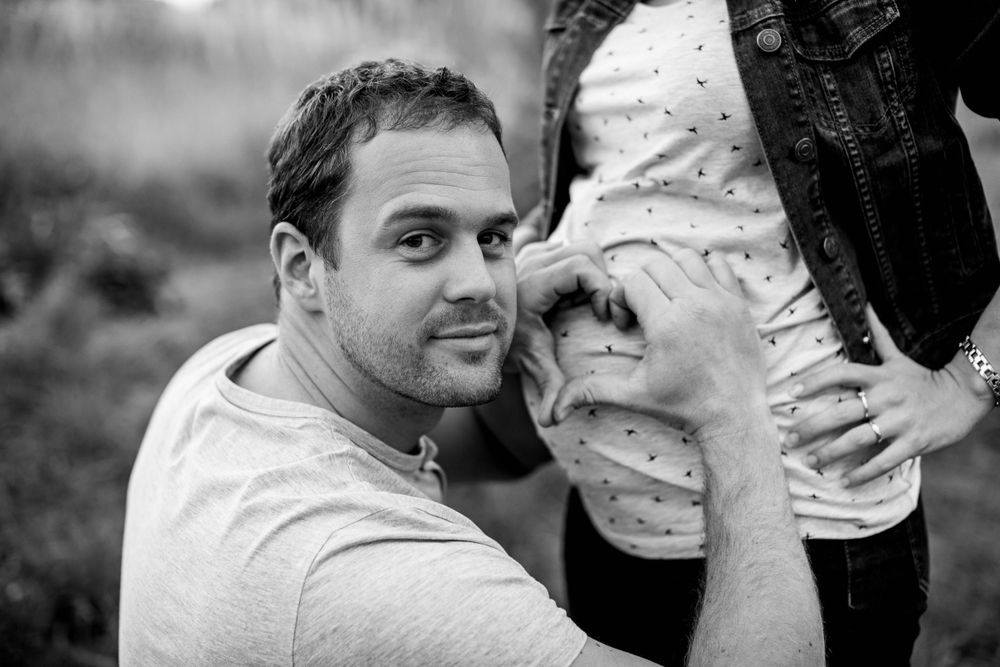 Close-up maternity photo showing hands gently cradling a pregnant belly.