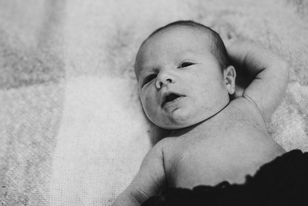 Black and white close-up of a peaceful newborn baby resting.