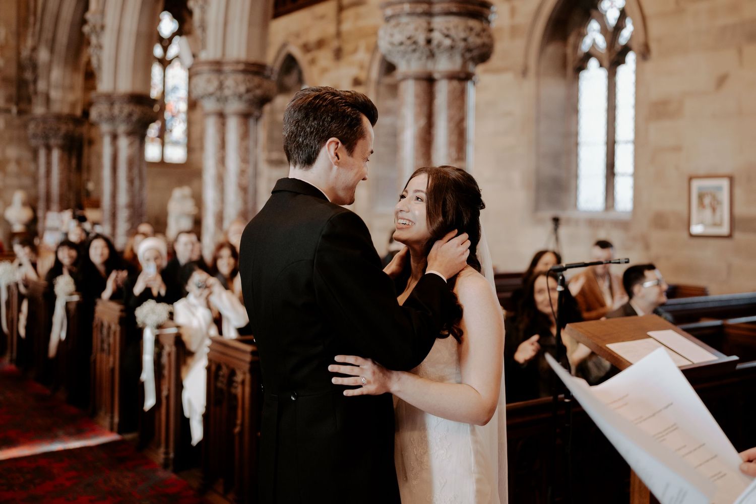 Beautiful cathedral interior with Gothic arches and stained glass windows during a ceremony.