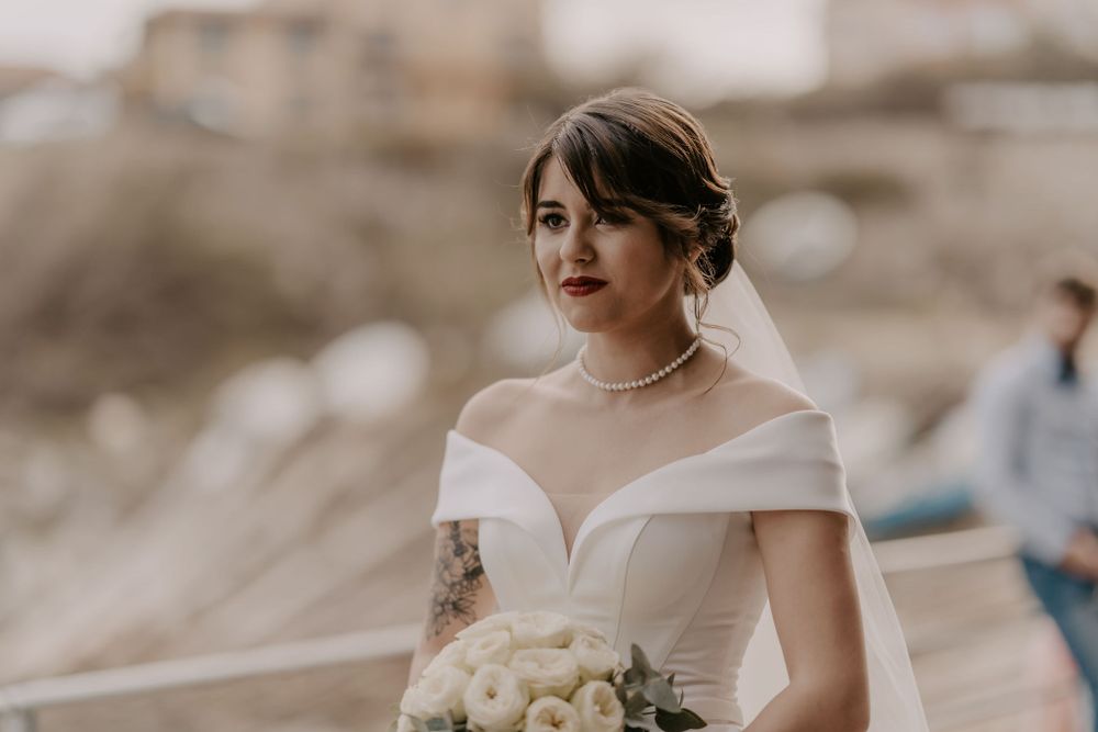 Bride in elegant white dress at outdoor wedding ceremony.