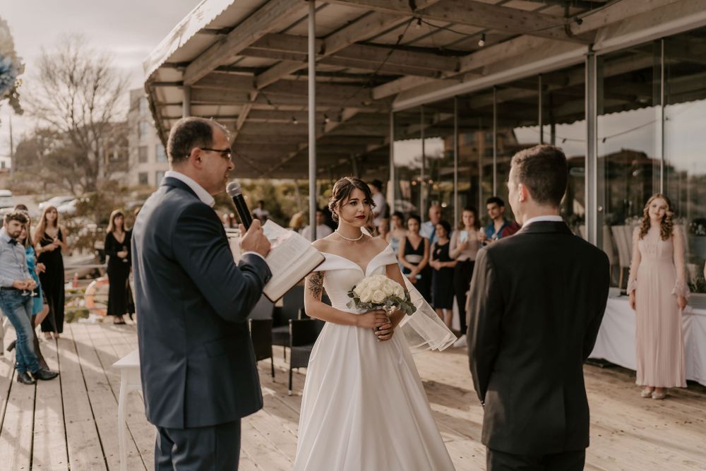 Wedding celebration on rustic covered deck with guests gathered to witness the ceremony.