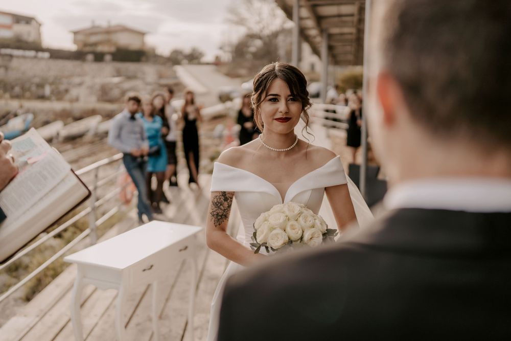 Emotional wedding ceremony moments captured on wooden deck overlooking water.