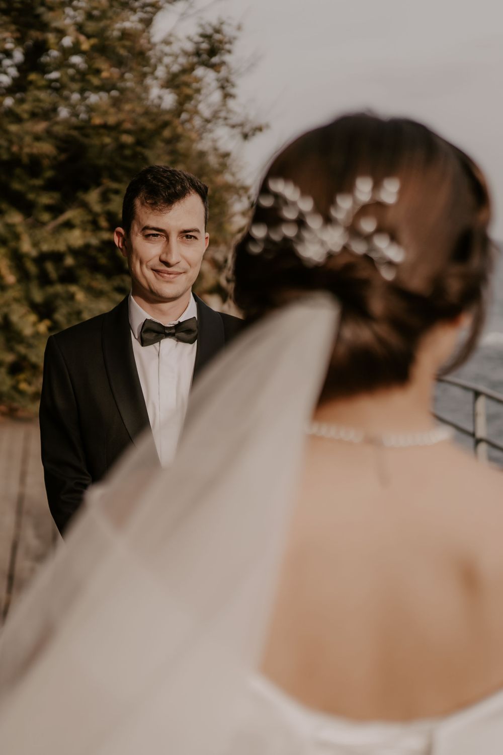 Intimate wedding ceremony moments with groom in classic black tuxedo and bow tie.