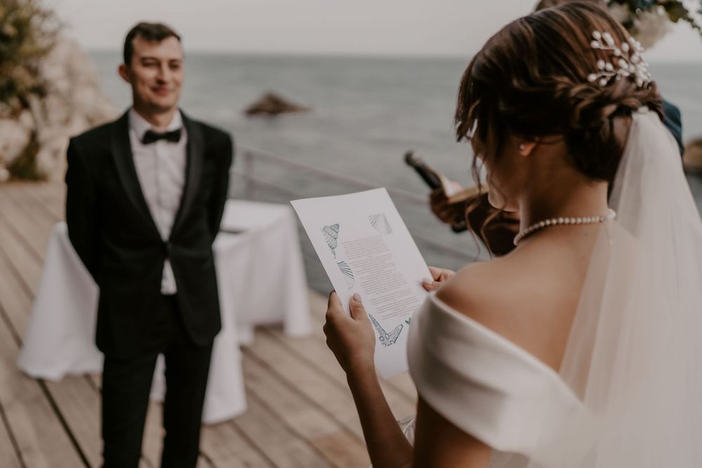 Wedding ceremony participants exchanging vows on scenic outdoor deck.