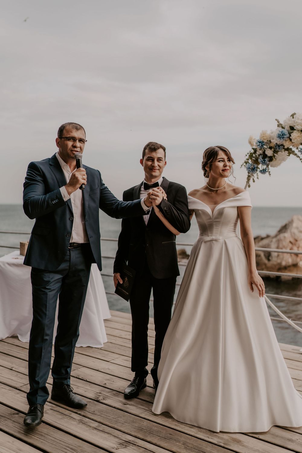 A celebratory moment captured on a waterfront deck during a wedding ceremony.