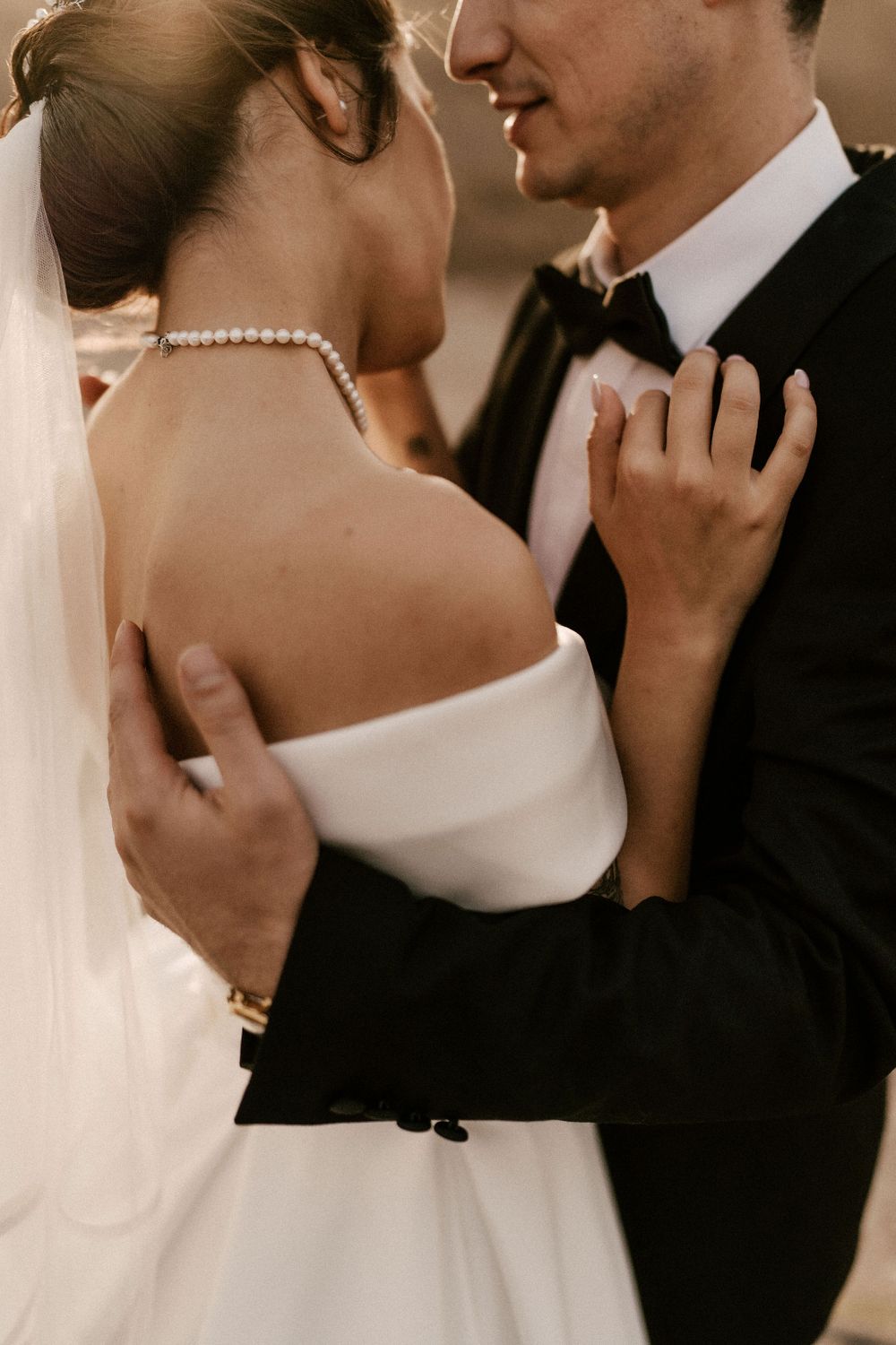 Intimate wedding portrait showing tender moments between newlyweds in formal attire.