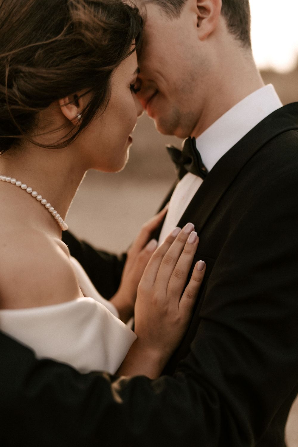 Artistic black and white wedding portrait capturing intimate moments between newlyweds.