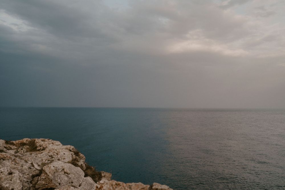 Moody seascape with dramatic clouds over a vast ocean horizon.
