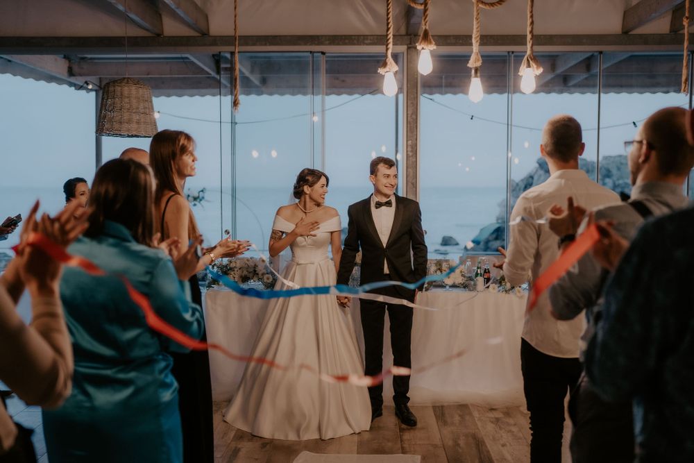 Guests celebrating at an elegant indoor wedding reception with panoramic views.