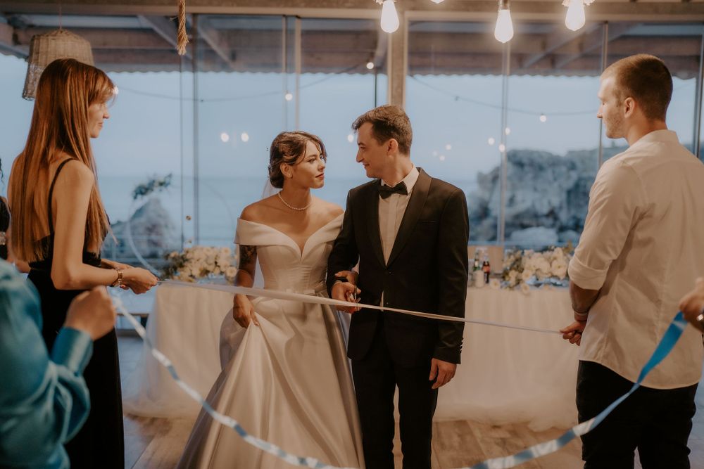 Wedding celebration in a contemporary venue with string lights and large windows.