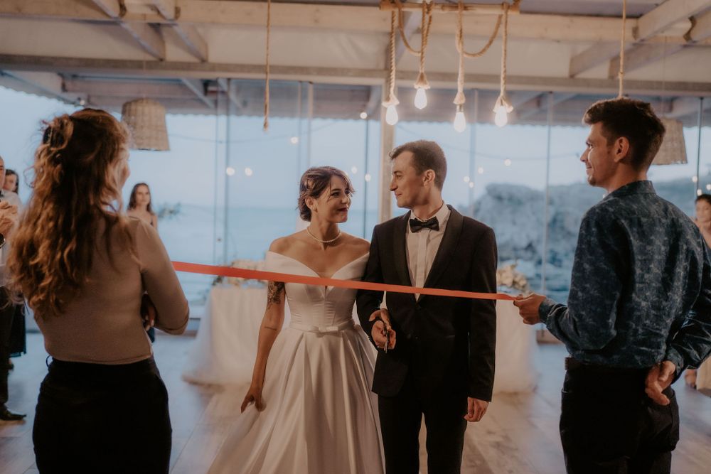 Elegant indoor wedding reception with guests mingling under pendant lighting.