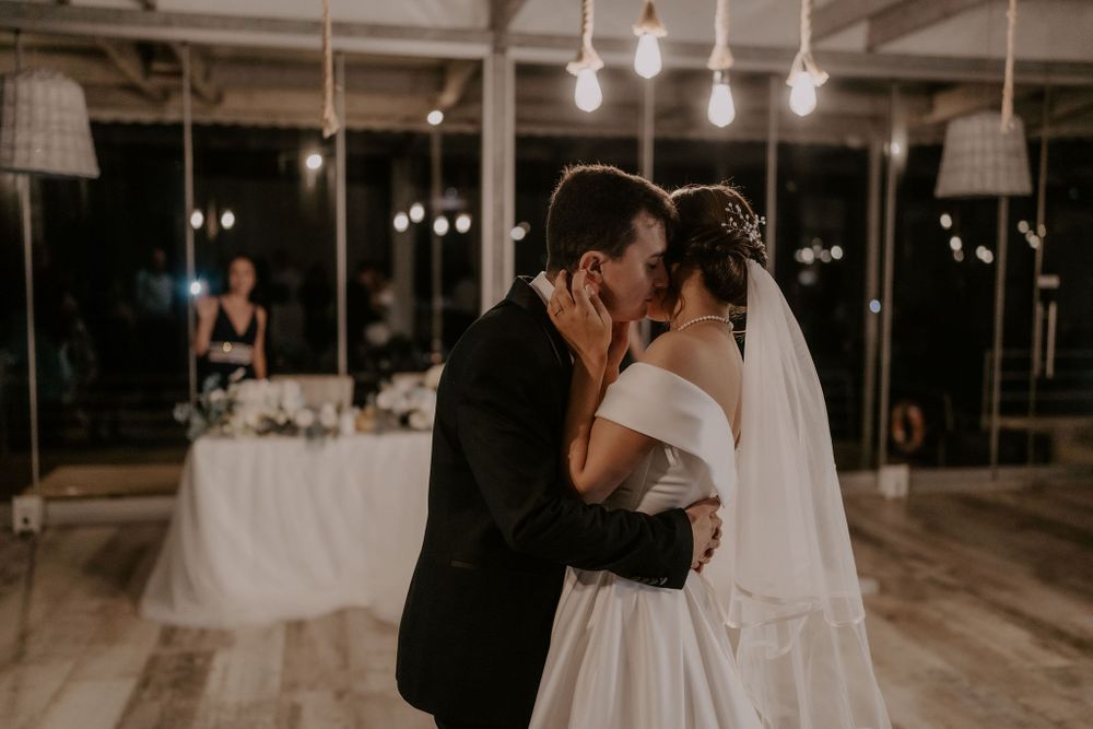 A romantic dance captured in sepia tones under industrial pendant lights.