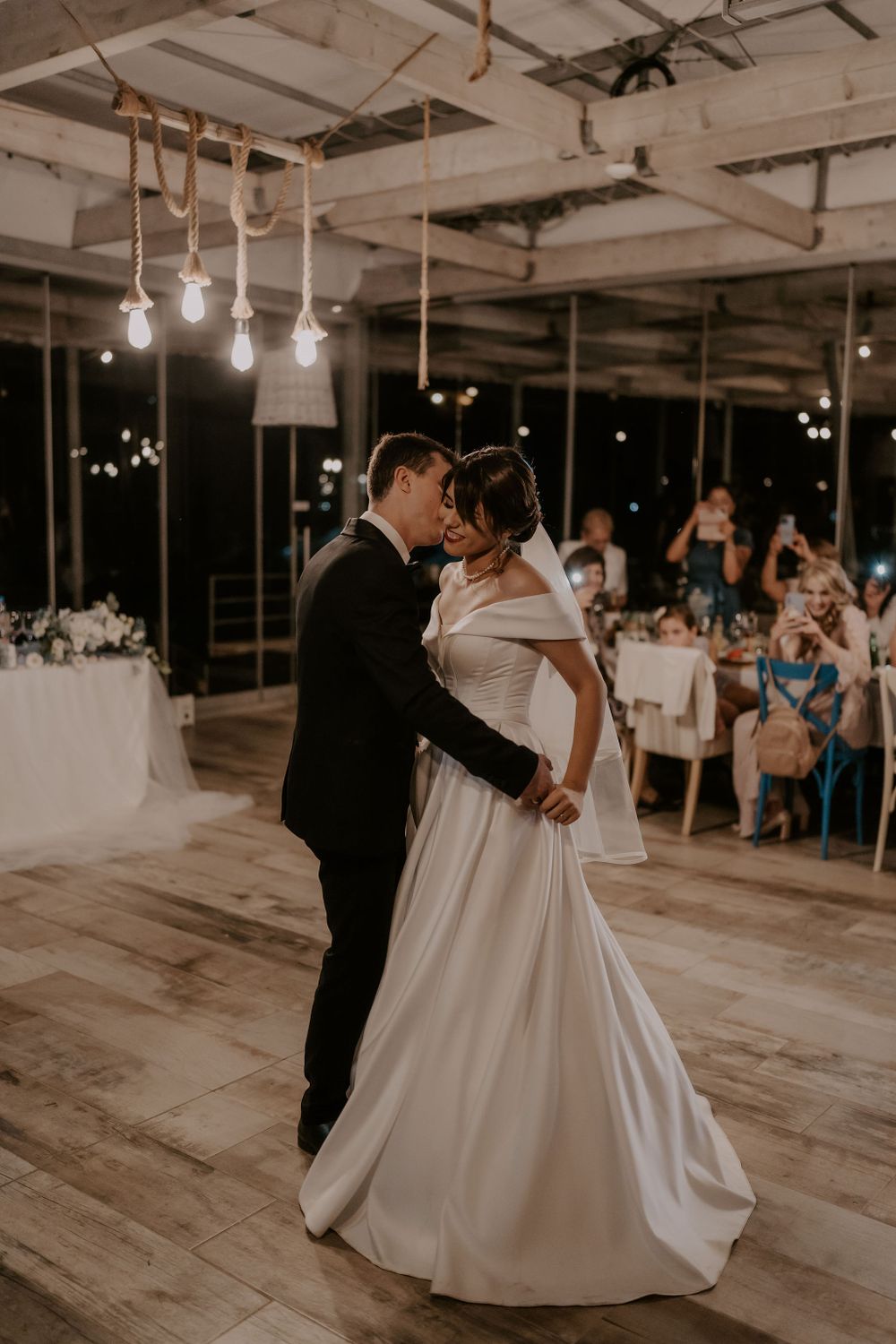 A couple shares an intimate dance moment in a modern industrial wedding venue.
