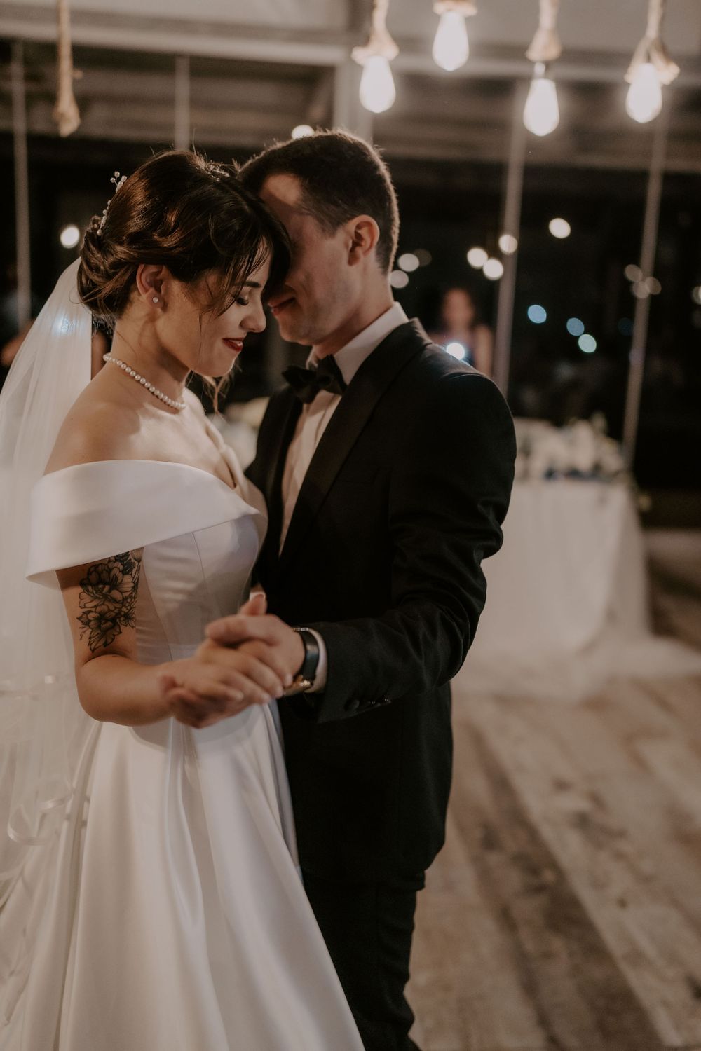 An intimate slow dance moment captured in a modern industrial wedding space.