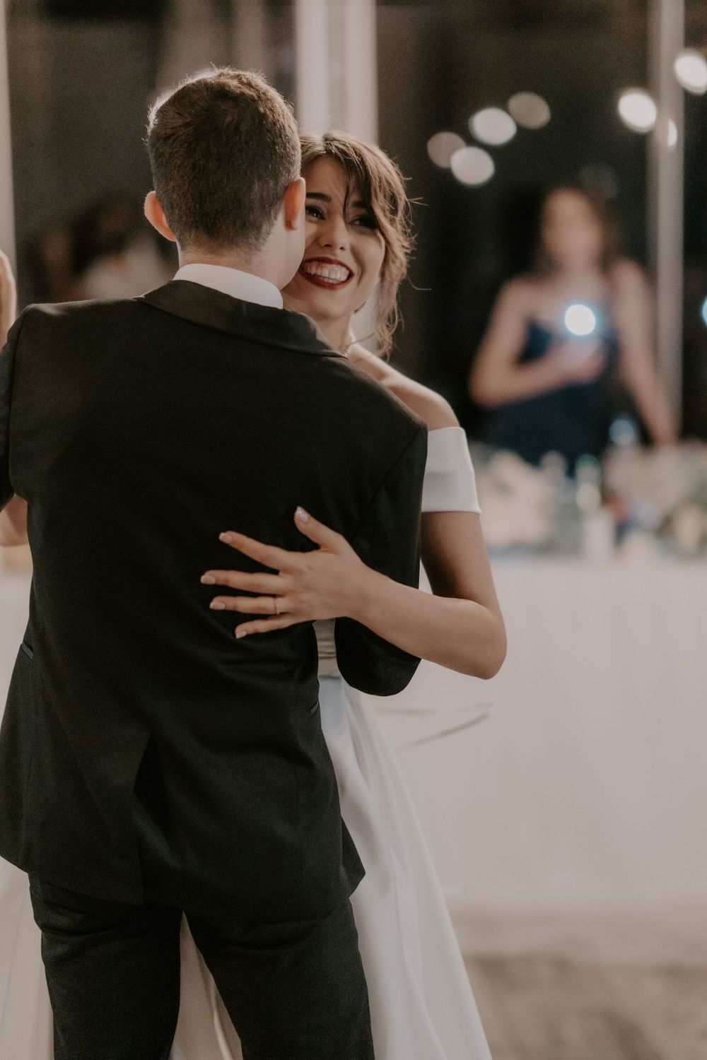 Couple sharing an intimate dance moment at their wedding reception with dreamy lighting.