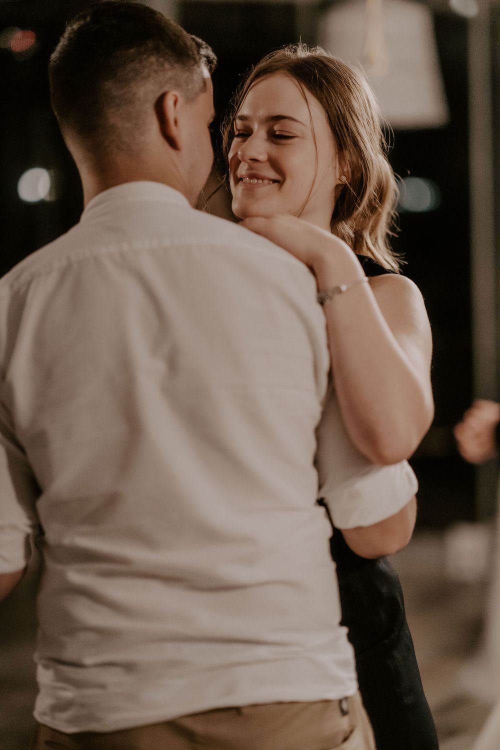 Intimate slow dance moment captured in warm lighting at a celebration.