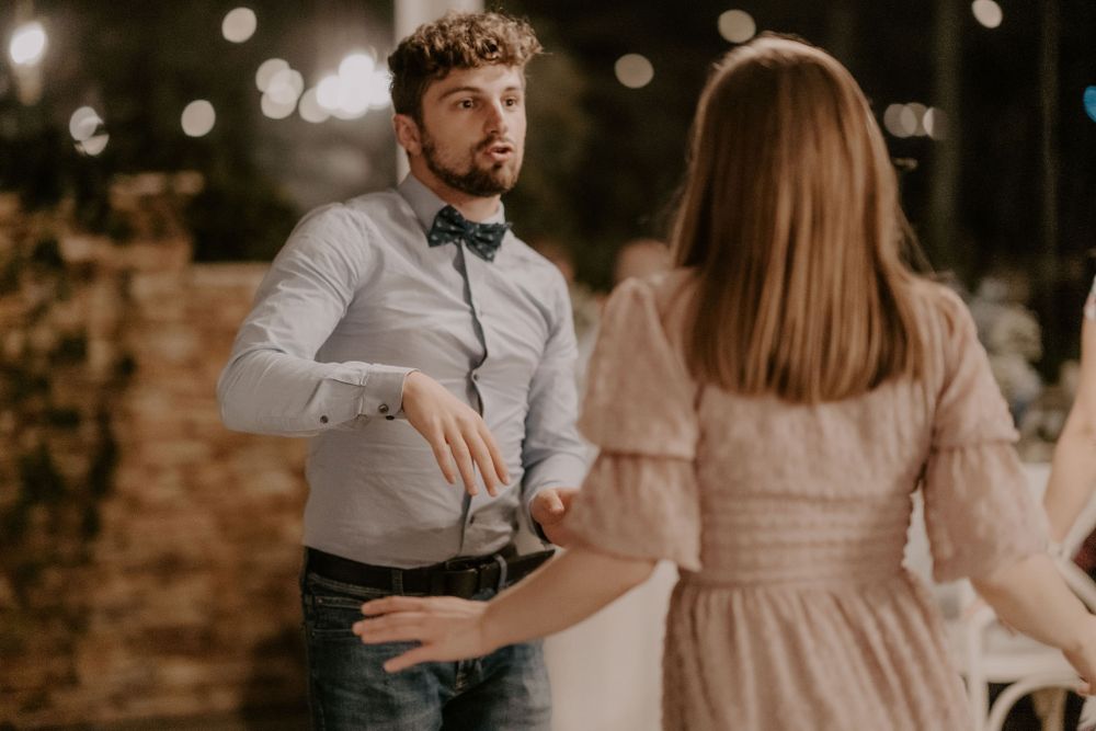 Couple dancing together in vintage-inspired outfits at an evening celebration.