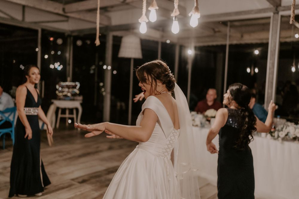 Wedding reception venue with string lights and guests mingling in an indoor space.