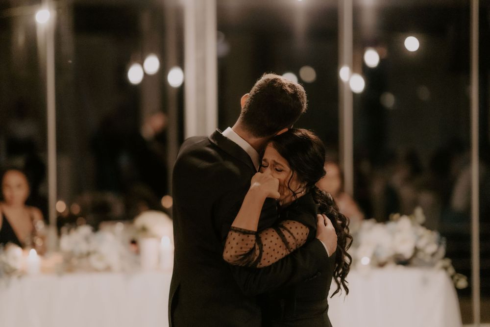 Evening wedding reception with bokeh lights and guests dancing in formal attire.