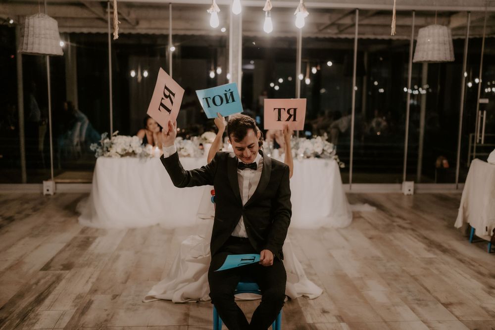 Wedding reception venue with industrial-style ceiling and ambient lighting.