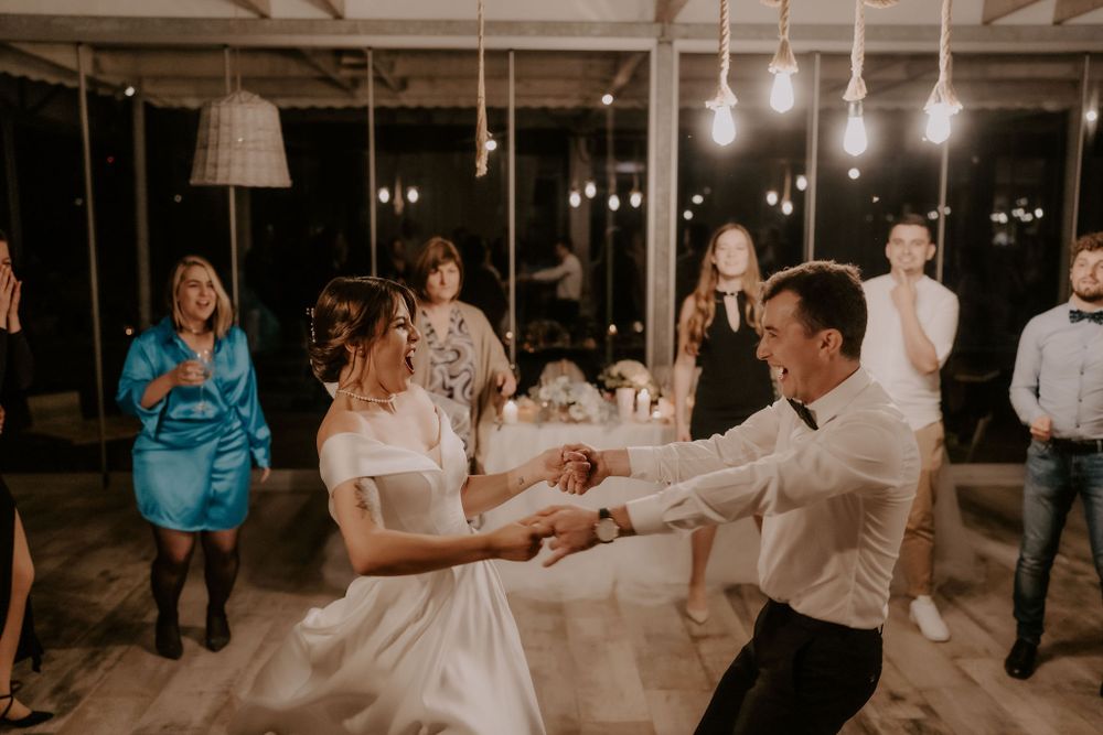 Couples dancing together at a wedding reception in an elegantly lit venue.