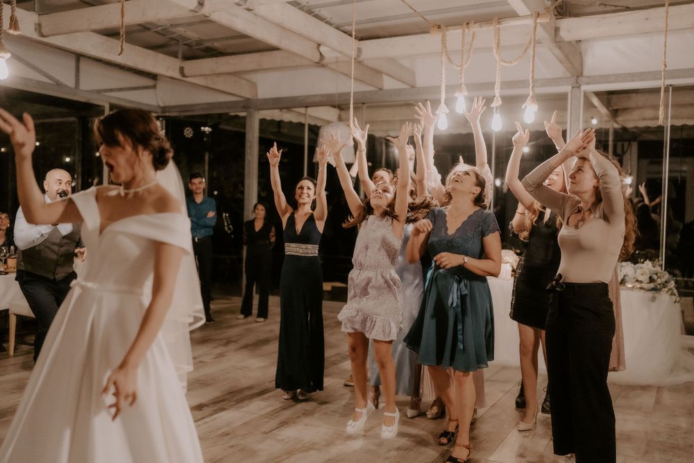 Wedding guests raise their hands in celebration while dancing at the reception.