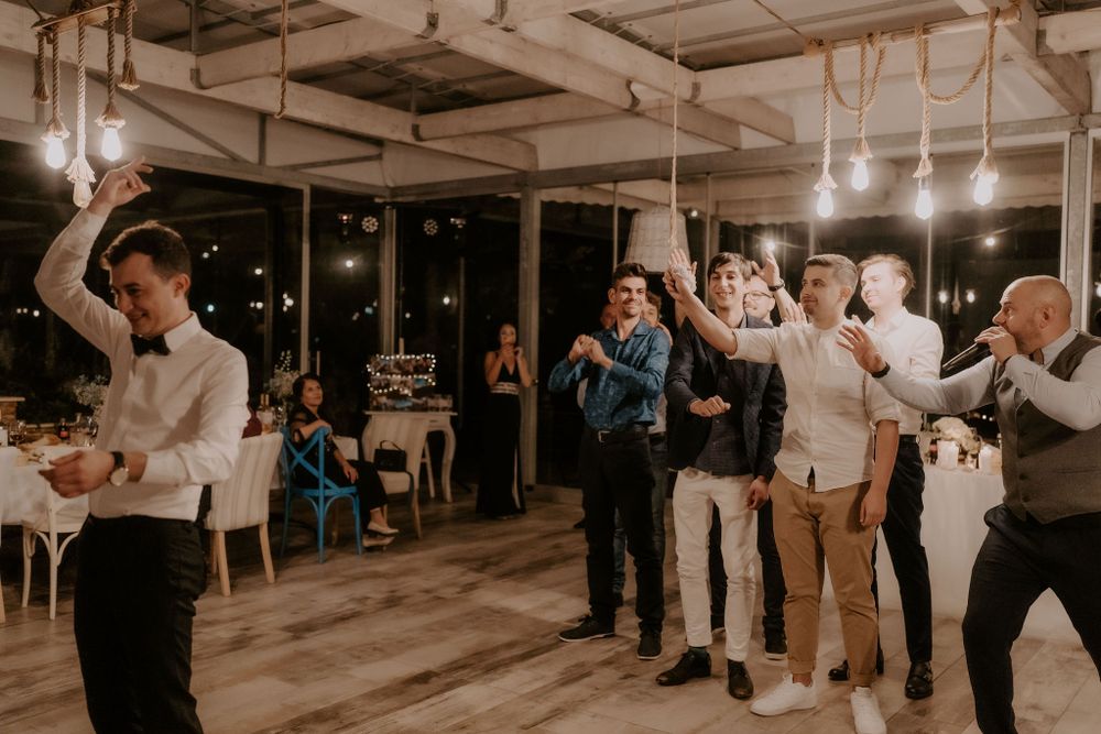 Wedding reception venue with hanging lights and guests gathered for celebration.