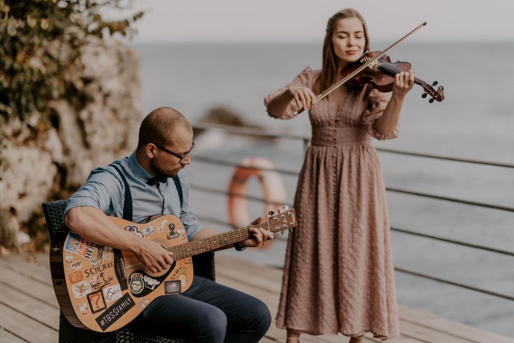 Musicians performing with string instruments at an outdoor venue.