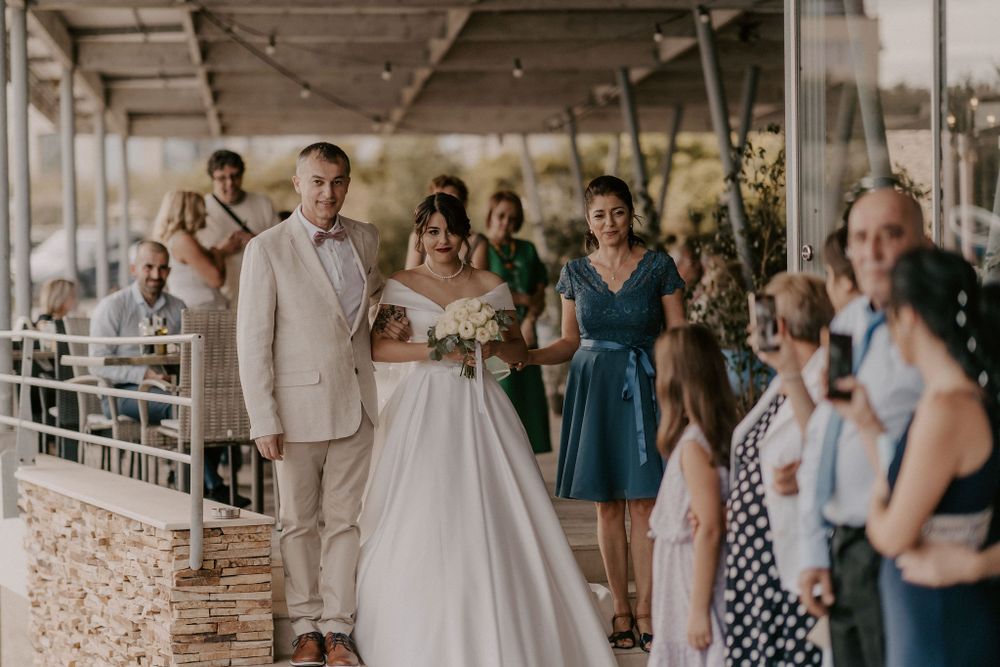 Wedding celebration with guests on an outdoor terrace.