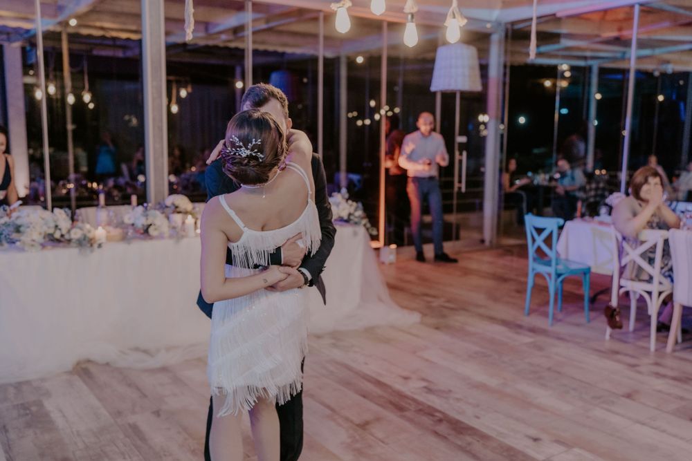 Spacious wedding venue with hanging lights and guests enjoying the celebration.