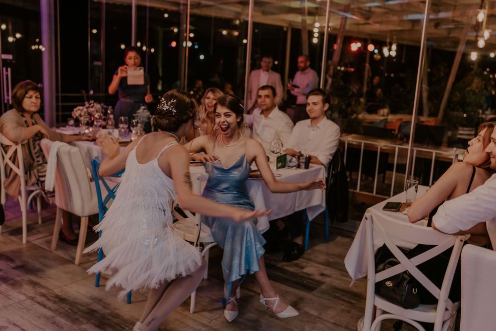 Wedding reception venue decorated with string lights and filled with celebrating guests.