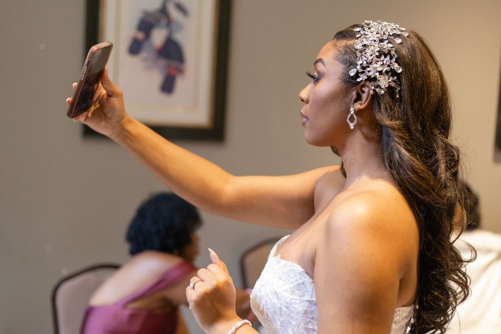 Looking in mirror while wearing crystal hair accessory and wedding dress.