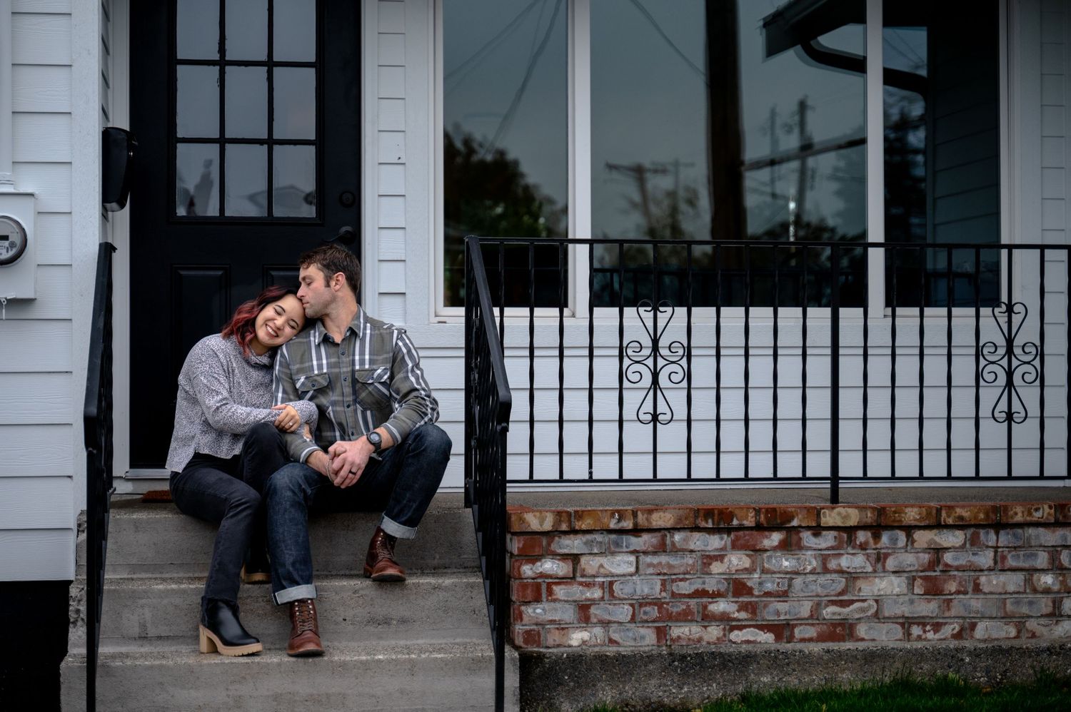 1st home buyer photoshoot in Tacoma Washington. Couple sitting on front porch.