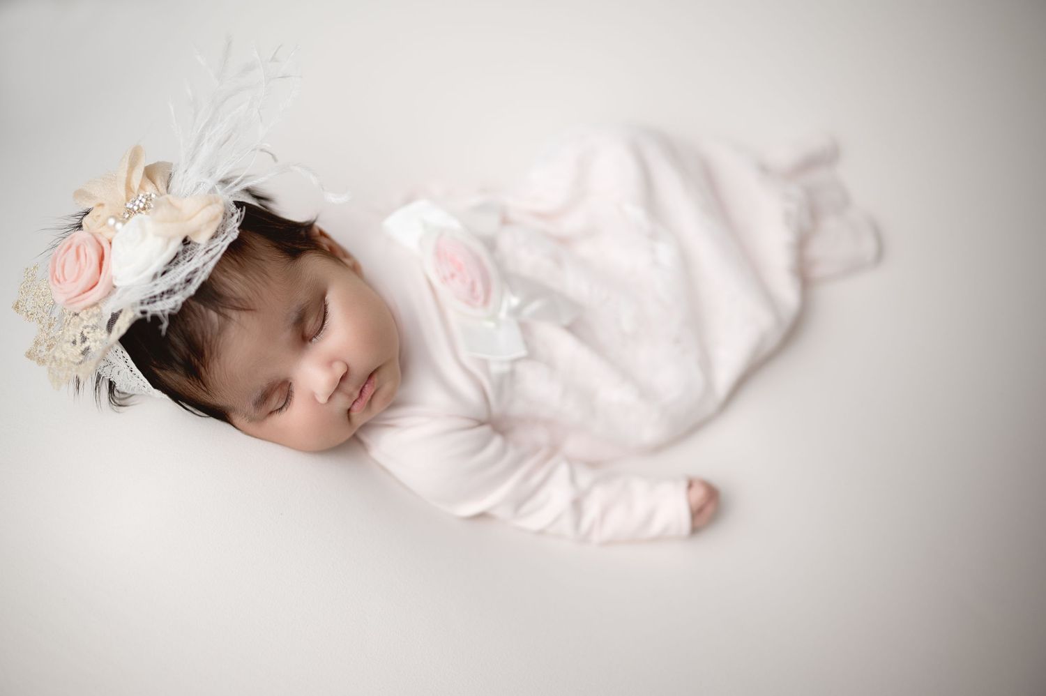 Side view portrait of newborn and sibling bonding on neutral background.