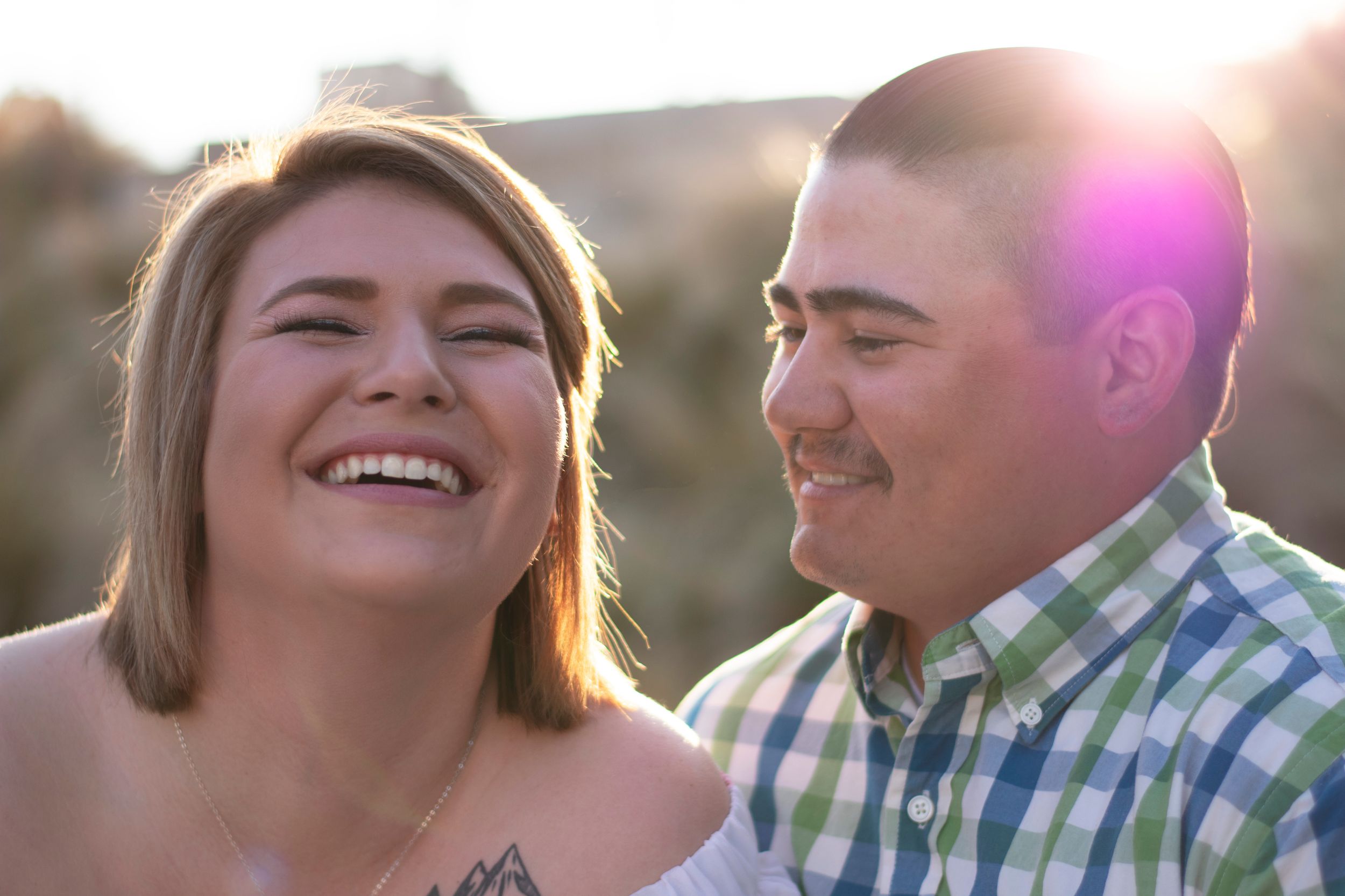 A couple can't help but laugh for the camera while they crack jokes during their engagement photo shoot