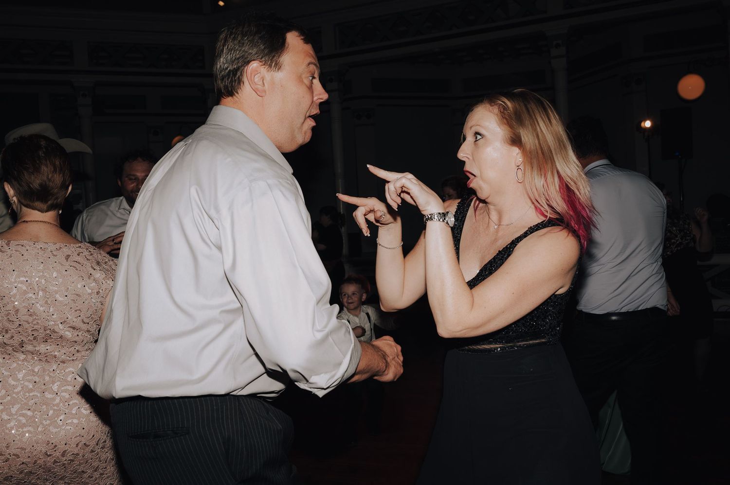 Couple having animated conversation while dancing at a reception.
