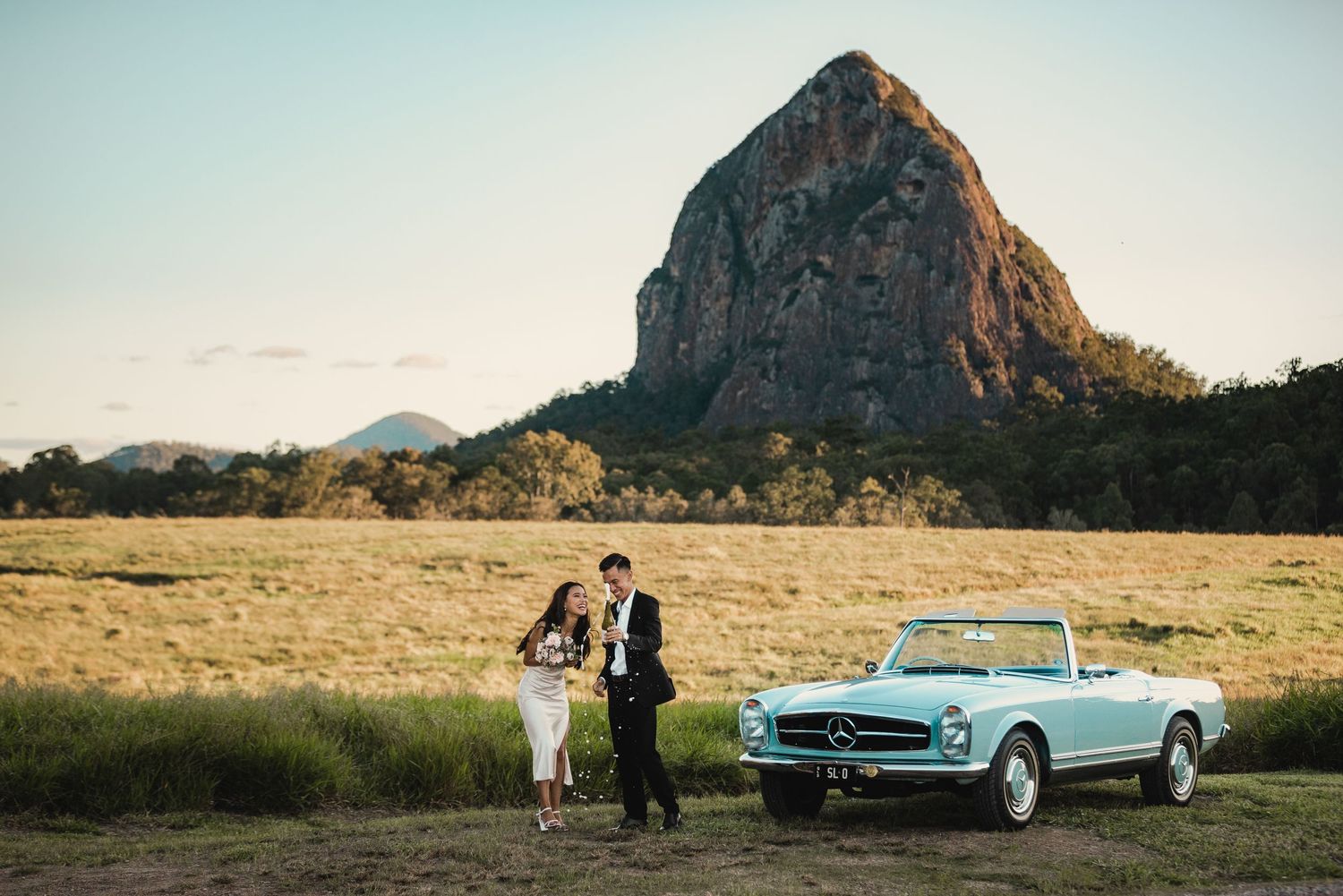 Bride and Groom popping champagne with mountain background