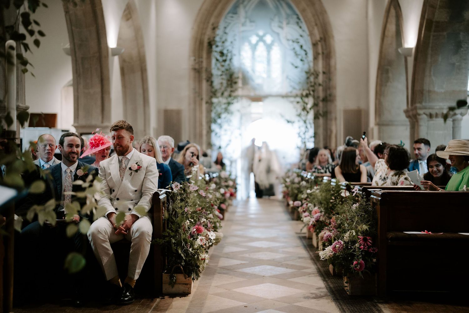 groom sat with his best man at the alter waiting for his bride to enter the church at st Nicholas church in Oxfordshire