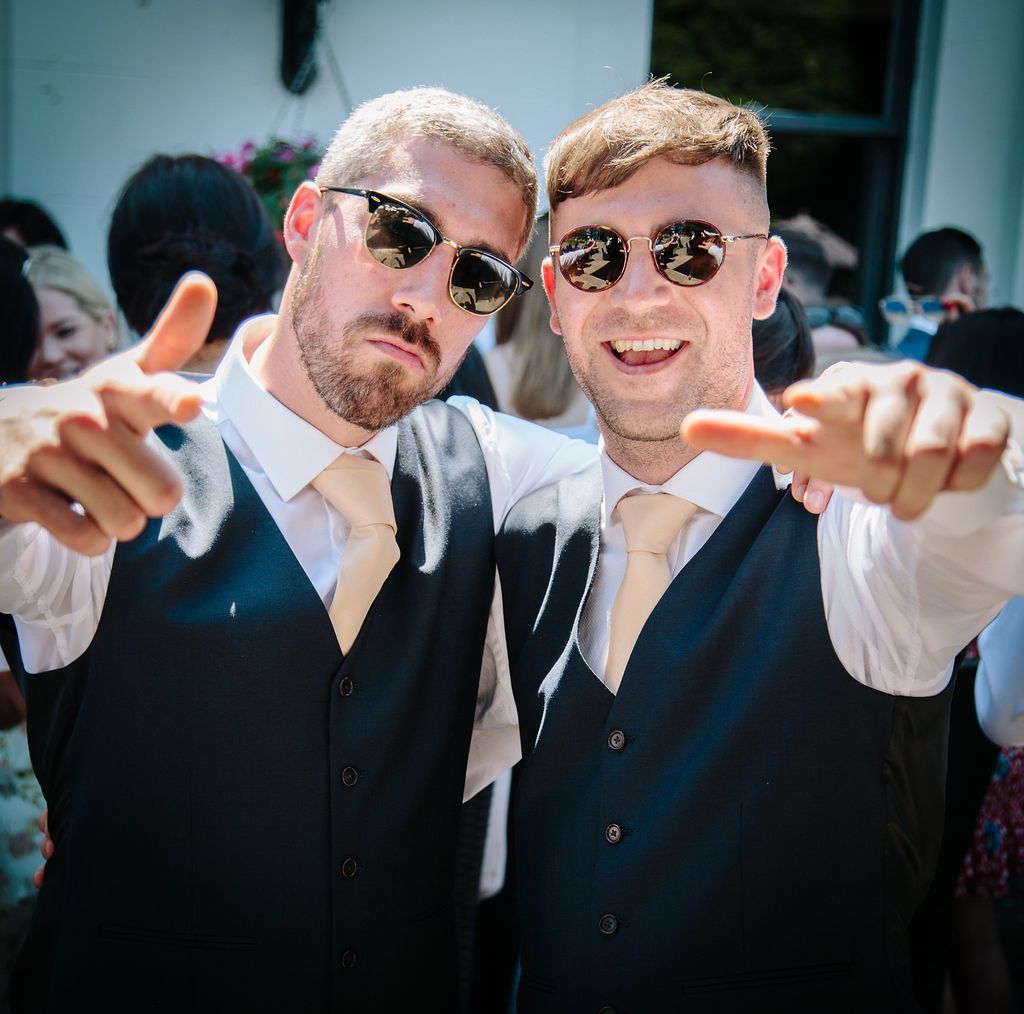 Best men with sunglasses on pointing at the camera
