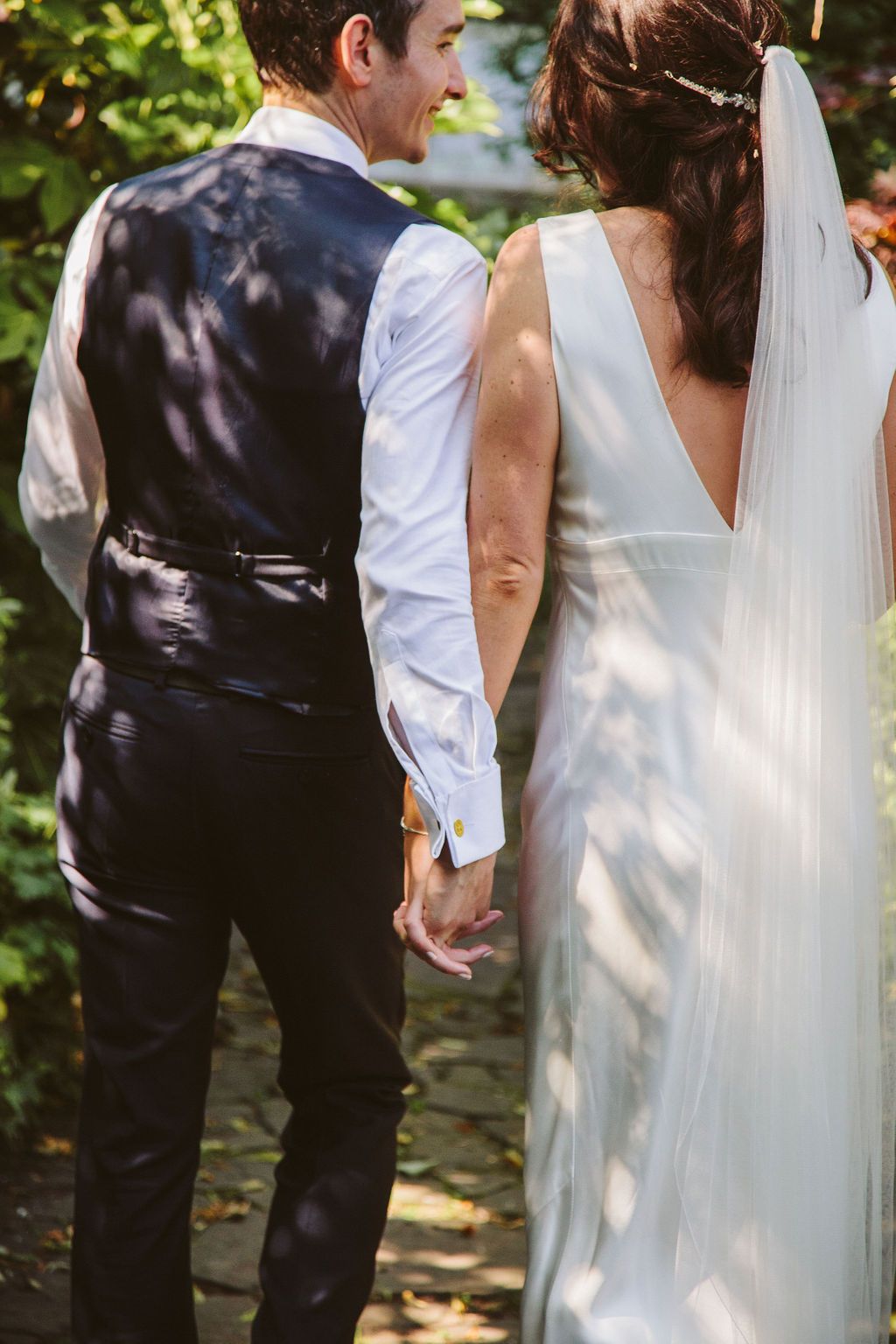 Back shot of bride and groom holding hands