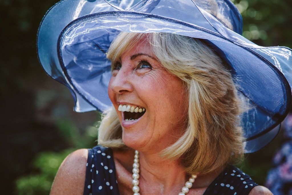 Mother of the bride with blue hat smiling