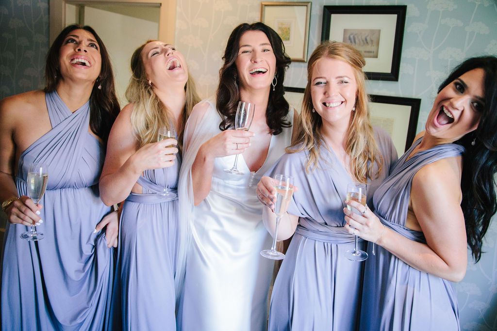 Bride and her bridesmaids laughing