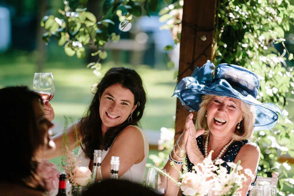 Mother of the bride and bride laughing at speeches