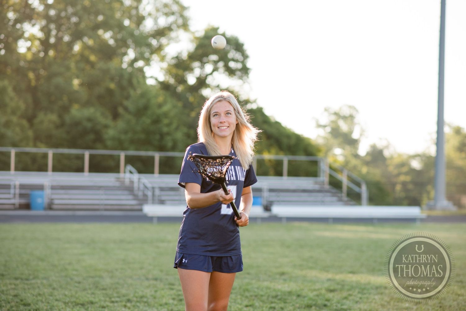 Candid sports portrait on field with bleachers visible in background at sunset.