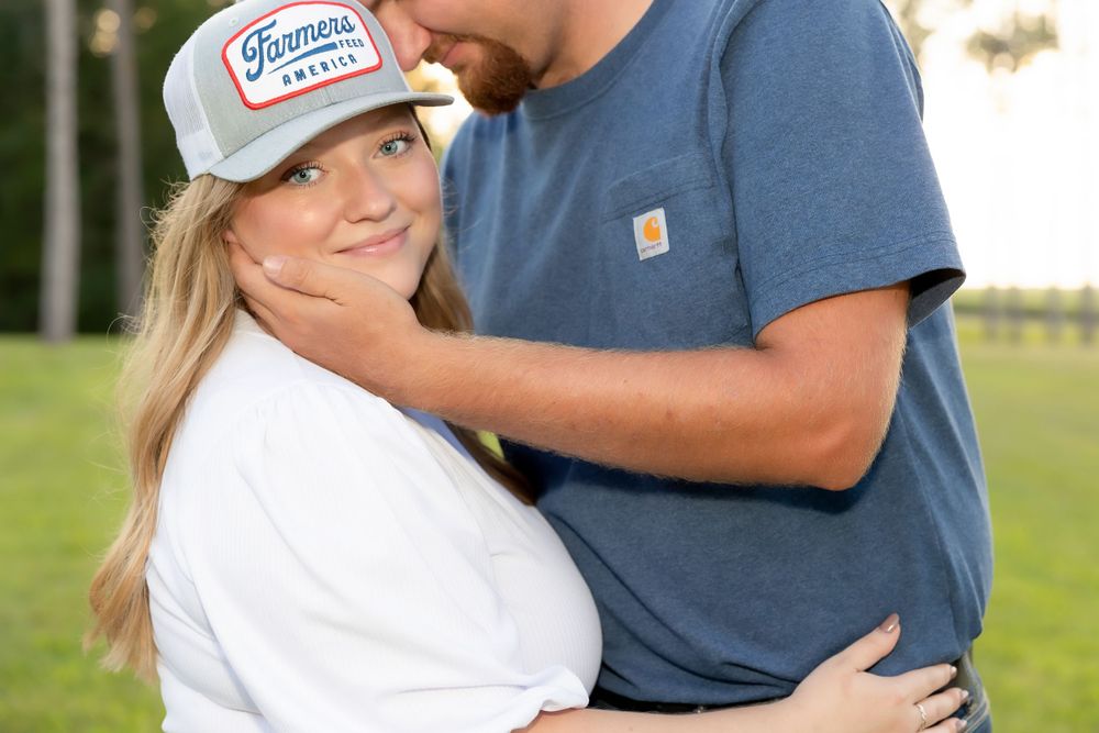 A tender moment between a couple in casual attire against a nature backdrop.