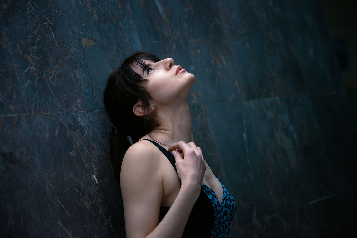 Woman wearing a swimsuit staring upwards illuminated with dramatic lighting