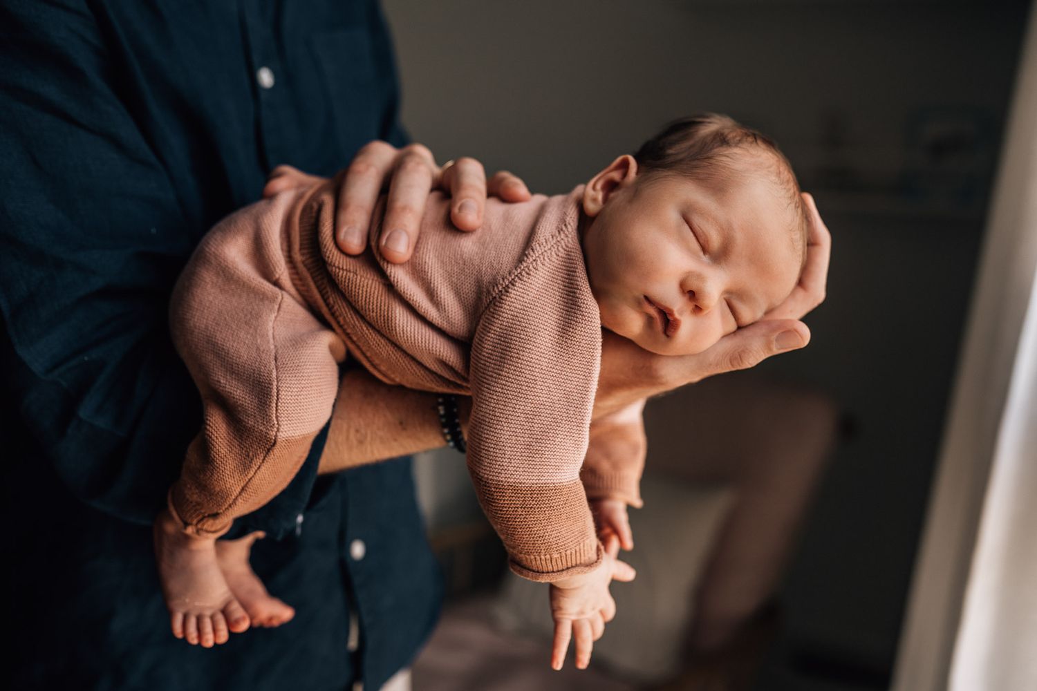 baby in dad's hands during Dubai lifestyle photography session